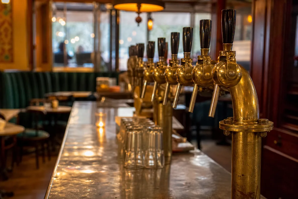 Rangée de tireuses à bière en laiton sur un comptoir de brasserie